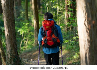 Asian Man Climbing A Mountain