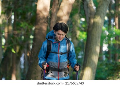 Asian Man Climbing A Mountain