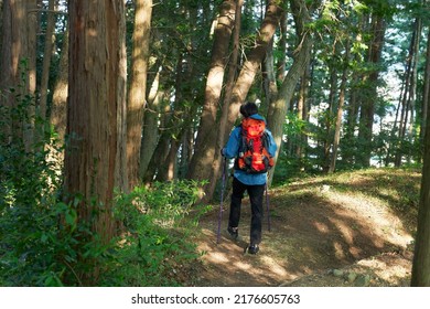 Asian Man Climbing A Mountain