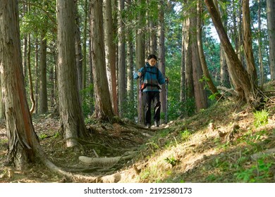 Asian Man Climbing A Mountain 