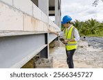 Asian man construction site manager structural engineer foreman worker wearing safety gear and helmet holding tablet planning project and inspecting progressing work for building architect development