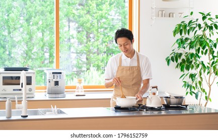 Asian Man Cooking With An Apron