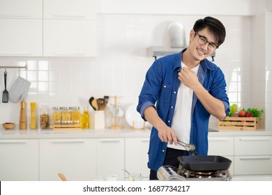 Asian Man Cooking With Grill Pan, Hot And Tried Feel In White Kitchen.