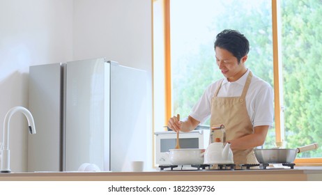 Asian Man Cooking At Home