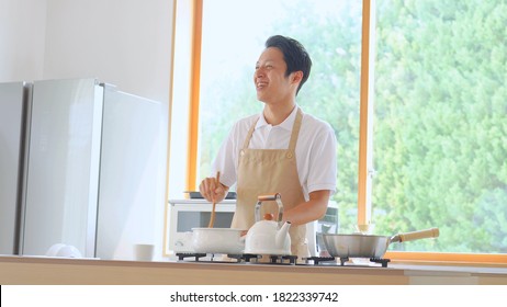 Asian Man Cooking At Home