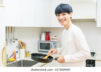 Asian Man Cooking In A Kitchen.