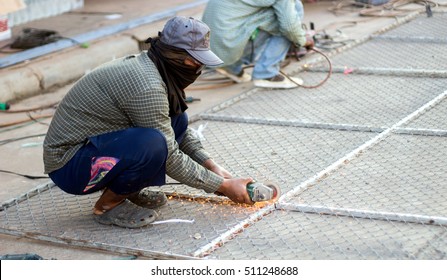 Asian Man Cutting Steel Net Cage With Electric Saw With No Safety 