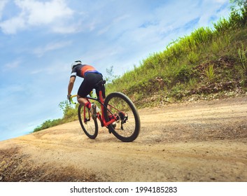 Asian Man Cycling On Gravel Road