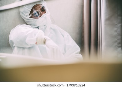 Asian Man Doctor In Protective Hazmat PPE Sad, Tire And Despair. Medical Staff In Clean Suit. Male Practitioner.