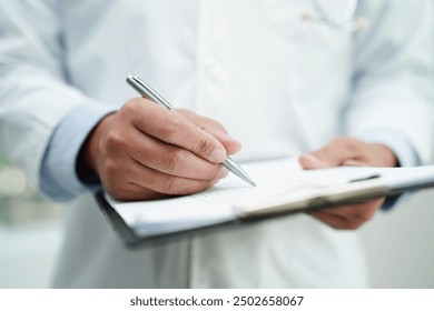 Asian man doctor study document to research method and technic for treating patients. - Powered by Shutterstock