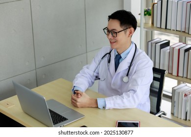 Asian Man Doctor Video Conference Patient On Laptop Computer,social Distance Coronavirus COVID-19 Concept 