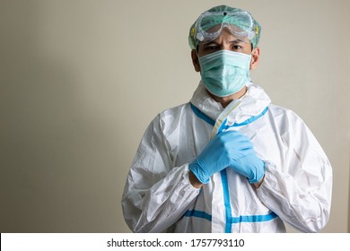 Asian Man Doctor Wearing  Personal Protective Equipment (PPE) Suit, Medical Face Mask, Face Shield And Goggle