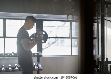 Asian Man Doing Barbell Curls In A Training Gym