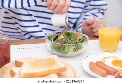 Asian Man Dressing A Large Salad