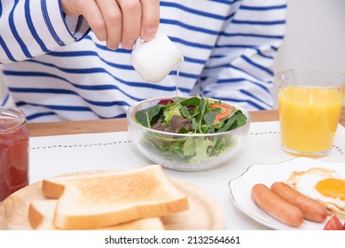 Asian Man Dressing A Large Salad