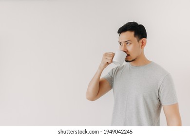 Asian Man Is Drinking Coffee Or Tea Isolated On White Background.