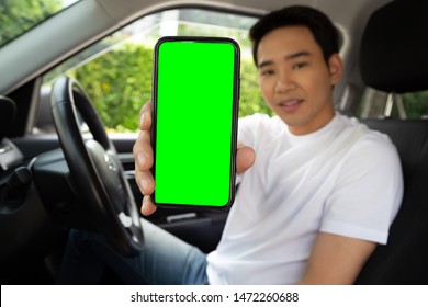 Asian Man Driver Sitting In The Car And Holding Mobile Phone With Green Screen Background