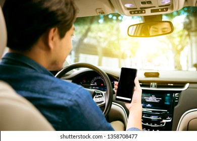 Asian man driving car using mobile internet navigation