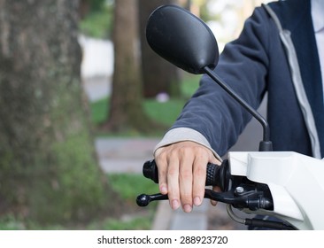 An Asian Man Driving A Scooter In Asia City.