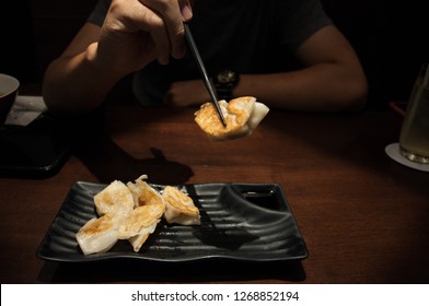 Asian Man Eating Dumplings At Japanese Restaurant, Gyoza