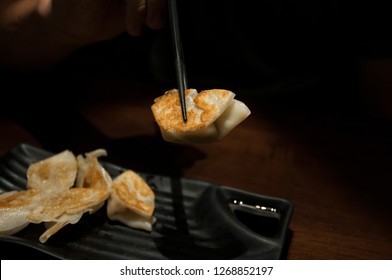 Asian Man Eating Dumplings At Japanese Restaurant, Gyoza