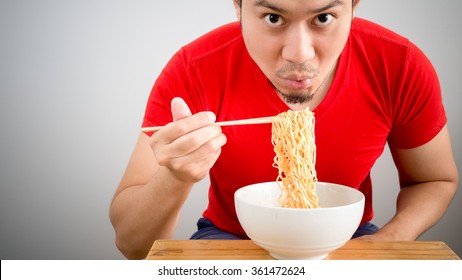 Asian Man Eating Instant Noodles.