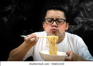 Asian Man Eating Instant Noodles Very Hot And Spicy On Black Background