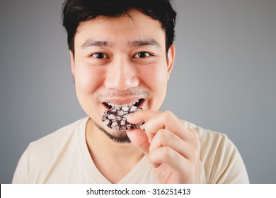 Asian man is eatting cookies.