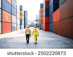 Asian man engineer and African man industrial worker walking and works at a container yard. Shipping business management and international goods import-export. Concept of Logistic operation. Diversity