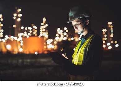 Asian man engineer using digital tablet working late night shift at petroleum oil refinery in industrial estate. Chemical engineering, fuel and power generation, petrochemical factory industry concept - Shutterstock ID 1425439283