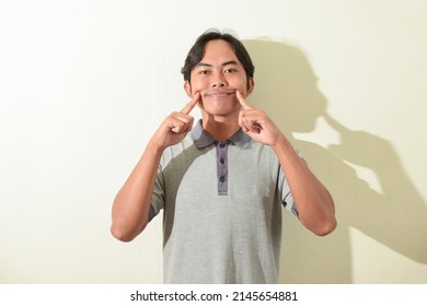 asian man facial expression forced, contrived, fake smile. portrait of indonesian man in gray t-shirt on white background isolated
 - Shutterstock ID 2145654881