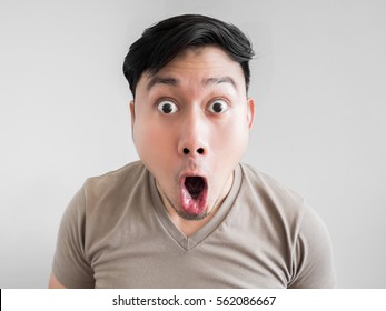 Asian man feels shock and surprise with overly face expression.