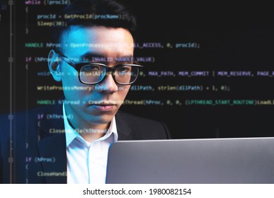 Asian Man Focusing On Programming With Lines Of Code Running On The Screen
