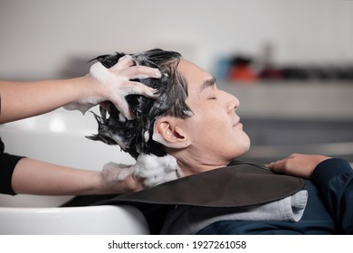 Asian Man Getting His Hair Washed In A Barber