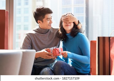 Asian Man Giving Young Woman Girlfriend A Christmas Or Birthday Gift