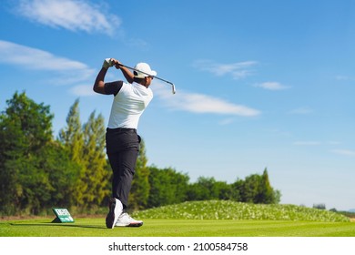 Asian Man Golfing On The Course In Summer