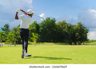 Asian Man Golfing On The Course. In Summer