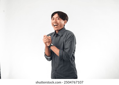 An Asian man in a gray shirt clapping his hands with a smile, looking towards the camera. The background is plain white, and the gesture suggests approval or appreciation.