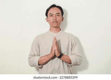 asian man with greeting gesture apologizing. hand gesture greeting symbol of welcome, apologize, greeting. Indonesian man wearing neat and polite shirt on white isolated background - Shutterstock ID 2278883299