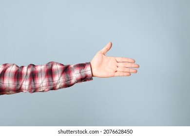 The Asian man hand with plaid shirt showing on the blue background.