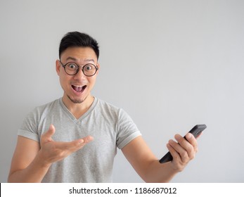 Asian Man Happy To See What In The Smartphone On Isolated Grey Background.