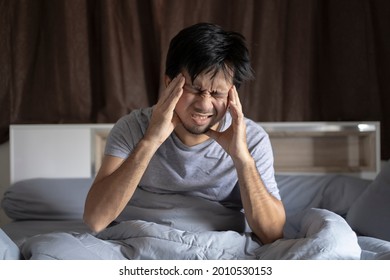 Asian Man Has A Headache After Waking Up.