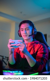 asian man have live stream and playing mobile game on the smartphone at home