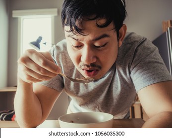 Asian Man Is Having A Boring Bolw Of Cereal As Breakfast.