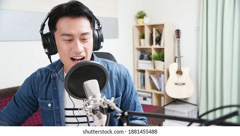 asian man with headphones and microphone recording podcast at studio - Powered by Shutterstock