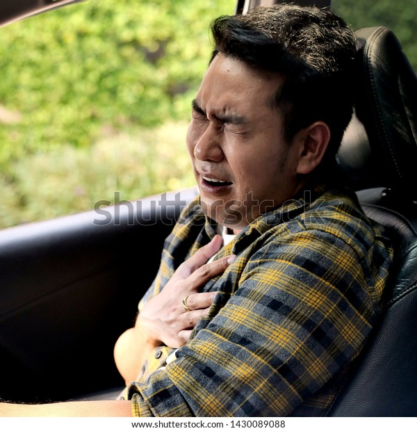 Asian\
man with heart attack in car, lifestyle\
concept.