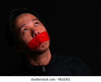 An Asian Man Held Hostage With Red Tape Over His Mouth