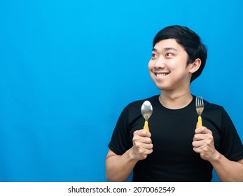 Asian Man Holding Cutlery Thinking About Food And Looking At Copy Space