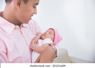 Asian Man Holding His Sleeping Baby Girl, Close Up