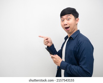 Asian Man Holding Mobile Phone Excited Point Finger At Copy Space Side View
